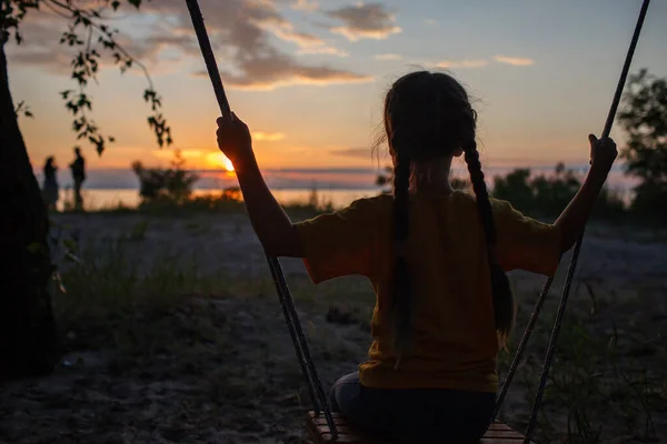 Girl on swing by sea in autumn sunset, family walk in nature, fall vibes, travel, active lifestyle — Stock Photo, Image