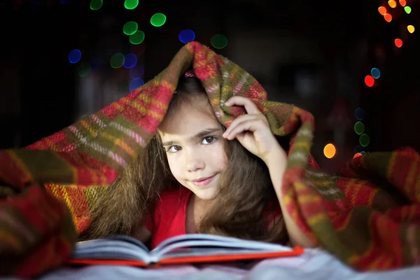 Barn läser en bok på sängen — Stockfoto