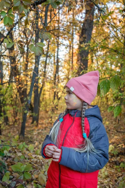 Chica preadolescente pensativa de pie solo en el hermoso bosque de otoño entre las hojas de oro — Foto de Stock