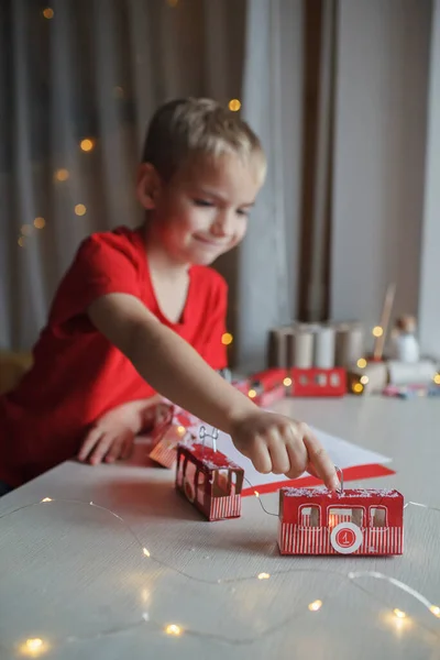 Chłopiec bawi się z crafted kalendarza adwentowego jak pociąg lub kolejka linowa wykonane z rolki papieru toaletowego w domu — Zdjęcie stockowe