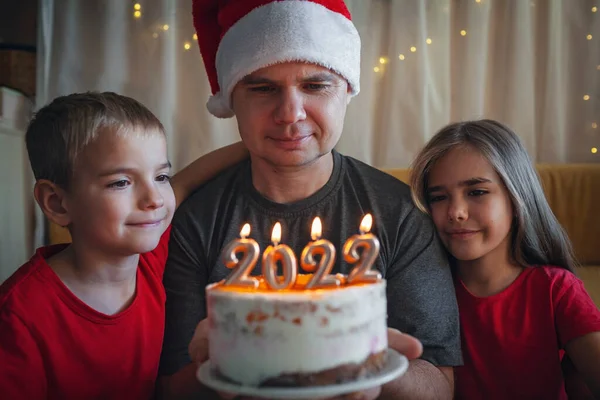 Tata z dziećmi przed bożonarodzeniowym tortem z liczbami, rodzinne święto Nowego Roku, uroczyste tło — Zdjęcie stockowe