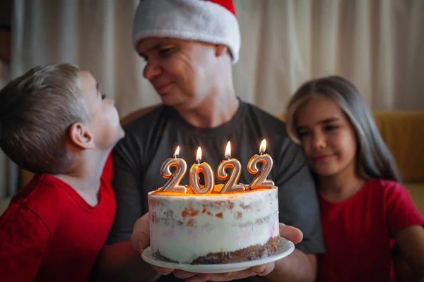 Tata z dziećmi przed bożonarodzeniowym tortem z liczbami, rodzinne święto Nowego Roku, uroczyste tło — Zdjęcie stockowe