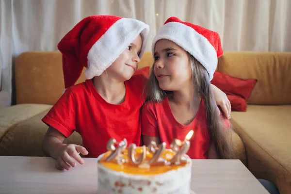 Szczęśliwy rodzeństwo przed świąteczny tort z liczbami, rodzina Nowy Rok uroczystości, uroczyste tło — Zdjęcie stockowe