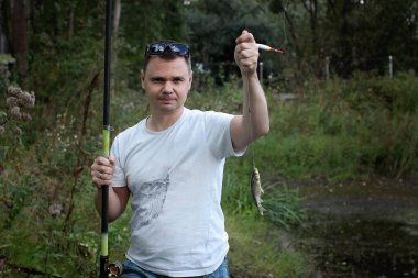 Yetişkin adam gölde balık tutuyor.