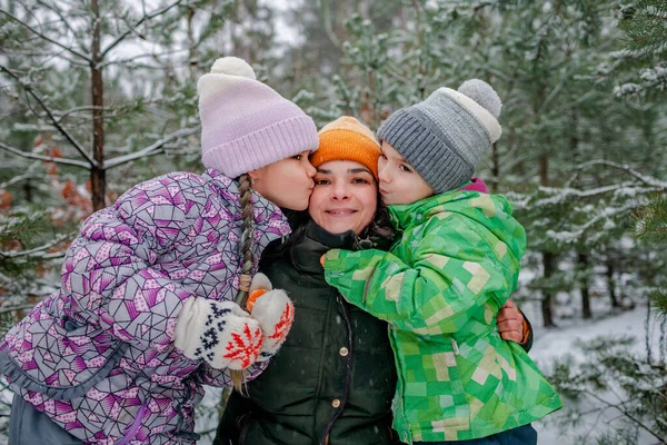 Barn med mamma njuta av första snön i vinterskogen, aktiva säsongsbetonade aktiviteter, livsstil — Stockfoto