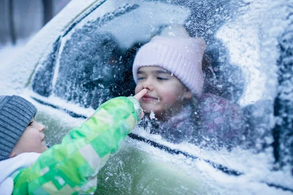 Menina pressionou o rosto contra o vidro da janela do carro engraçado achatamento nariz, viagem de estrada da família no inverno — Fotografia de Stock