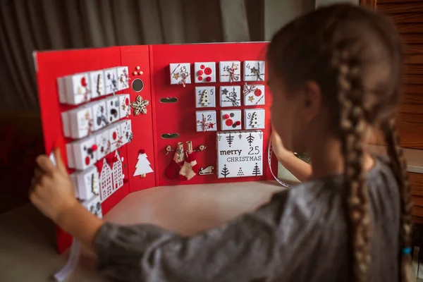 Красива дівчина має оригінальний календар пригод, зроблений з ювелірних коробок і зв'язувальних пристроїв, різдвяні ремесла — стокове фото