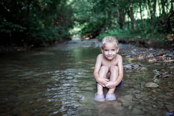 Kid baths in stream river in mountains, natural pool and spa. Cold water, wildlife. Green tourism — Foto de Stock
