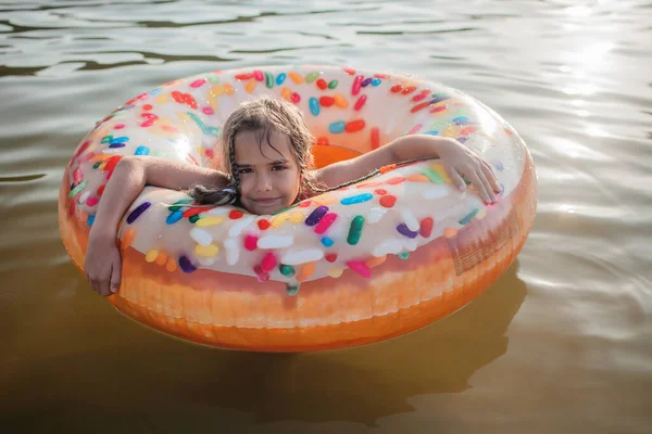 Chica nada con el anillo inflable de la rosquilla grande en el lago en el día caliente del verano, verano feliz, cottagecore — Foto de Stock