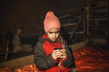 Ukraynalı kız sığınakta oturur, çay içer ve Rus işgalcilerin hava saldırısının bitmesini bekler.