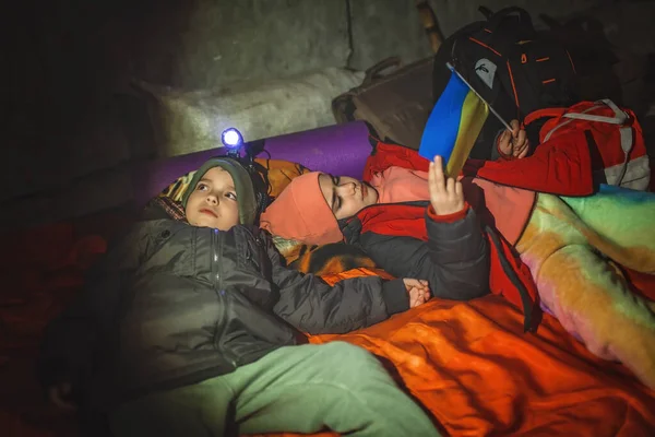 Copiii cu steag ucrainean se află într-un adăpost pentru bombe și așteaptă sfârșitul atacului aerian al invadatorilor ruși — Fotografie, imagine de stoc