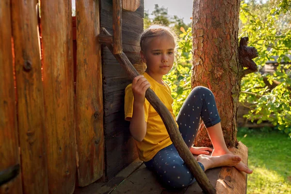 Girl plays in creative handmade treehouse in backyard, summer activity, happy childhood, cottagecore — Stock Photo, Image