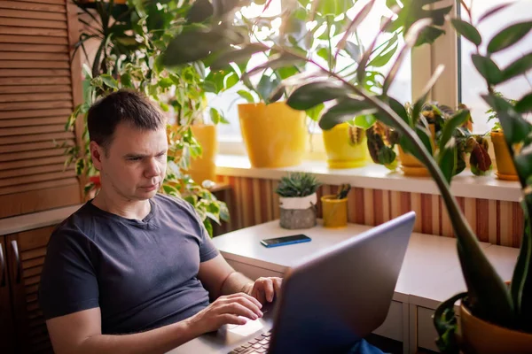 Чоловік працює з ноутбуком віддалено від дому. Віддалене робоче місце з зеленою природою надихнуло домашній офіс — стокове фото