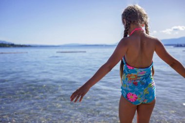 Mutlu kız mavi suya giriyor, bol bol eğlence ve mutluluk, yaz tatili, seyahat ve yaz tatili, yaşam tarzı