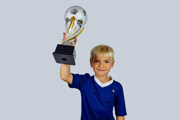 Young Soccer Player Blue Jersey Raising Trophy Winning Goal Football — Stock Photo, Image