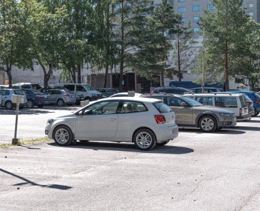 Şehre park etmiş eski, beyaz ve yeşil arabalar.