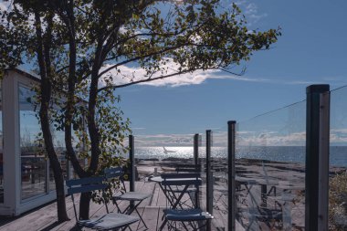 Denizde plaj sandalyeleri olan ahşap bank.