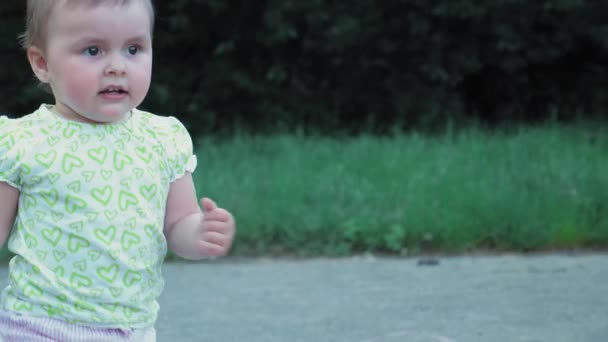 Mała Dziewczynka Wpada Zieloną Trawę Dziewczynka Koszulce Spodenkach Spaceruje Parku — Wideo stockowe