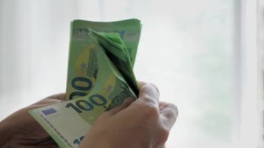 100 Euro 'luk banknotlarla kadın eli, bir yığın para sayıyor. Yüksek kalite 4k görüntü
