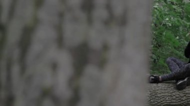 Genç bir kız ormanda bir kütüğe oturur ve telefonda konuşur. Kamera bir ağacın arkasından görüntü alıyor. Ormanın ortasında devrilmiş bir ağaca bir kadın oturuyor. Yüksek kaliteli FullHD görüntüler