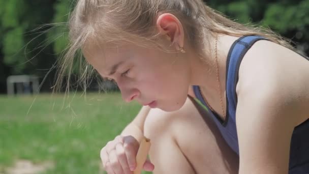 Портрет Красивой Девочки Подростка Сидящей Парке Траве Читающей Книгу Жующей — стоковое видео