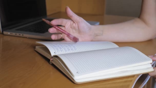 Woman Taps Notepad Ballpoint Pen Notebook Table Next Laptop Girl — Stockvideo