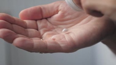 The heart-shaped pills are poured into the palm of your hand. A woman pours heart pills from a bottle. High quality 4k footage