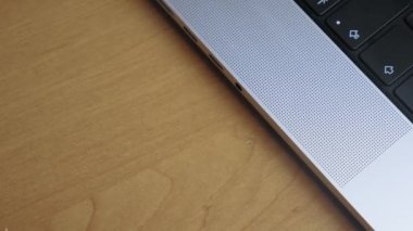 A man puts headphones into the headphone jack of a laptop. Close-up of man inserting wire with headphone connector into laptop. Connecting headphones to laptop via wire. High quality 4k footage