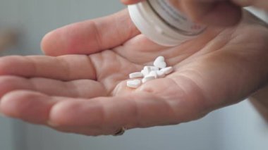 The heart-shaped pills are poured into the palm of your hand. A woman pours heart pills from a bottle. High quality 4k footage