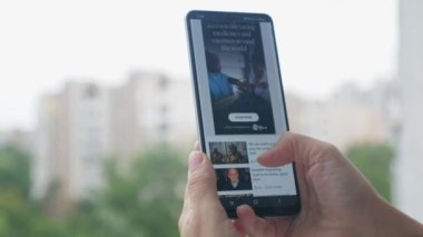 Close-up hands with a phone and watching the latest news. A woman monitors the latest world news. News today on bbs news. 15.08.2022 Ukraine Kiev. High quality 4k footage