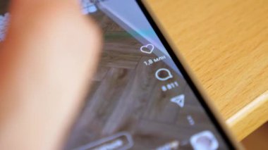 A person scrolls through a video on social networks and likes it. The girl watches short videos on the Internet. A woman is watching Reels. High quality 4k footage