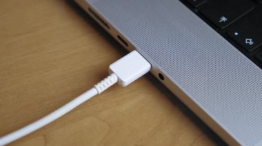Bir insan dizüstü bilgisayar konnektörüne C tipi kablo çekiyor. Telefondan veri transferi, telefon şarjı. Yüksek kalite 4k görüntü