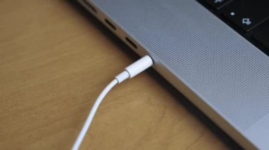 Birisi kulaklığı bir dizüstü bilgisayarın kulaklığına takıyor. Kulaklık kablosunu dizüstü bilgisayara çeken birinin yakın çekimi. Kulaklığı laptoptan çıkarıyorum. Yüksek kalite 4k görüntü