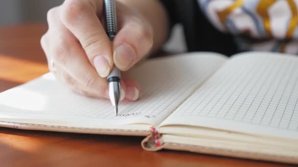 Een Vrouw Schrijft Met Een Pen Een Notitieboekje Close Het — Stockvideo