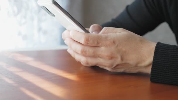 Una Chica Sienta Una Habitación Cerca Ventana Escribe Mensaje Teléfono — Vídeos de Stock