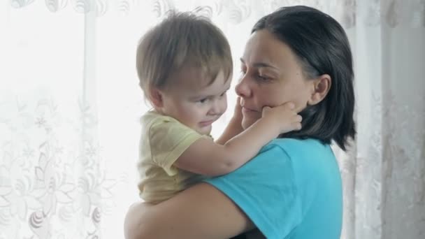 母親は小さな子供と一緒に腕の中で踊る 女の子は部屋に立っている間に赤ん坊を振る 高品質4K映像 — ストック動画