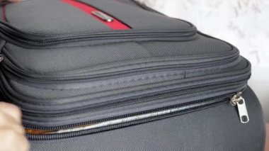 Yakın plan kadın elleri valizi açar ve kilitle bağlar. Kız seyahatten döndükten sonra bavulunu boşaltıyor. Yüksek kalite 4k görüntü