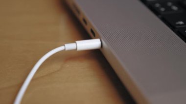 Birisi kulaklığı bir dizüstü bilgisayarın kulaklığına takıyor. Kulaklık kablosunu dizüstü bilgisayara çeken birinin yakın çekimi. Kulaklığı laptoptan çıkarıyorum. Yüksek kalite 4k görüntü