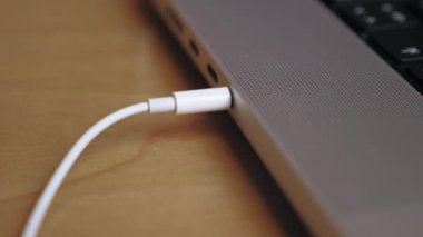 Birisi kulaklığı bir dizüstü bilgisayarın kulaklığına takıyor. Kulaklık kablosunu dizüstü bilgisayara çeken birinin yakın çekimi. Kulaklığı laptoptan çıkarıyorum. Yüksek kalite 4k görüntü