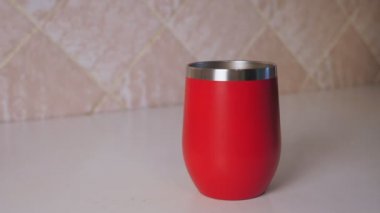 Bir kadının eli, çay poşetini kırmızı kupaya indirir. Kız mutfakta çay hazırlıyor. Yüksek kalite 4k görüntü