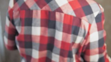 Ekose gömlekli bir adam sırtına siyah bir sırt çantası fırlatıyor. Adamın biri omzuna siyah bir sırt çantası takıyor. Yüksek kalite 4k görüntü