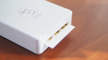 Mini yazıcı küçük bir çocuğun fotoğrafını basıyor. Akıllı telefonlar için kablosuz mini yazıcı. Evde taşınabilir bir yazıcıyla fotoğraf basma işlemi. Fotoğraf albümü için küçük baskılar. Yüksek kalite 4k
