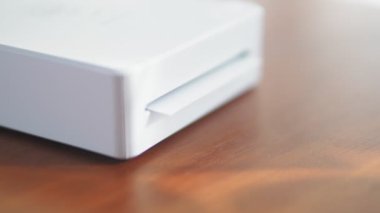 Mini yazıcı küçük bir çocuğun fotoğrafını basıyor. Akıllı telefonlar için kablosuz mini yazıcı. Evde taşınabilir bir yazıcıyla fotoğraf basma işlemi. Fotoğraf albümü için küçük baskılar. Yüksek kalite 4k