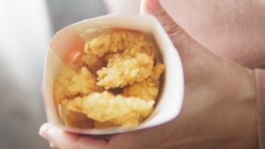 Kız elinde bir karton tepsi ve fast food tutuyor. Kadınlar abur cuburla yakın çekim yapar. Yüksek kalite 4k görüntü