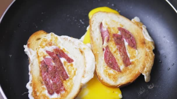 在一片土司中间煎的鸡蛋和香肠片 也被称为篮子里的鸡蛋 用面包中的鸡蛋做的一餐的特写 在家做早餐的主意 高质量的4K镜头 — 图库视频影像