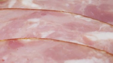 Jambon ince dilimlere bölünmüş. Dilimlenmiş sosis yarım daire şeklinde dizilir. Makro video. Yüksek kalite 4k görüntü