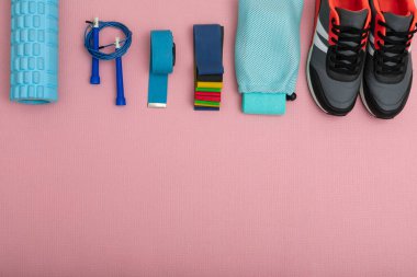 Spor malzemelerinin ve spor kıyafetlerinin fotokopi alanı ve metin yeri olan pembe fitness minderinin üst görüntüsü