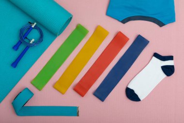 Spor malzemelerinin ve spor kıyafetlerinin en üst görüntüsü pembe fitness minderinde.