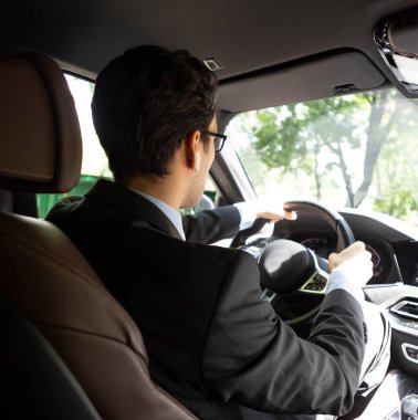 Lüks arabasını kullanan işadamına geri bakış