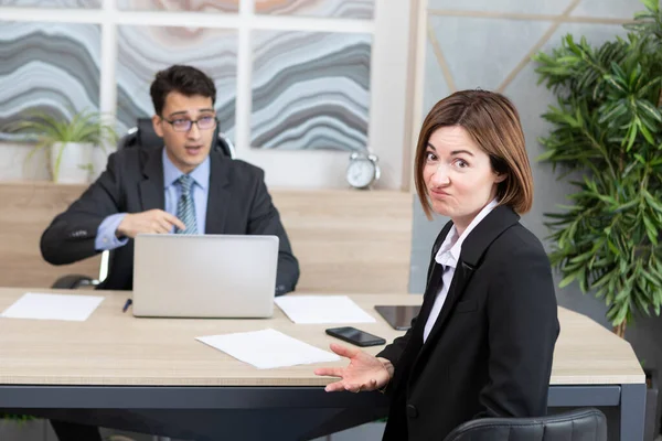 Confused woman in suit feeling stress on interview in the office